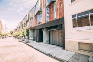 Commercial overhead metal grille door installation on San Francisco strip